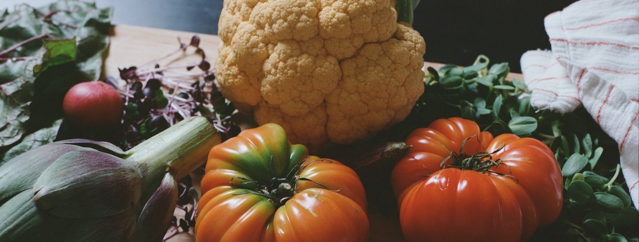 Produce on table - microgreens, tomato, artichoke, lettuce
